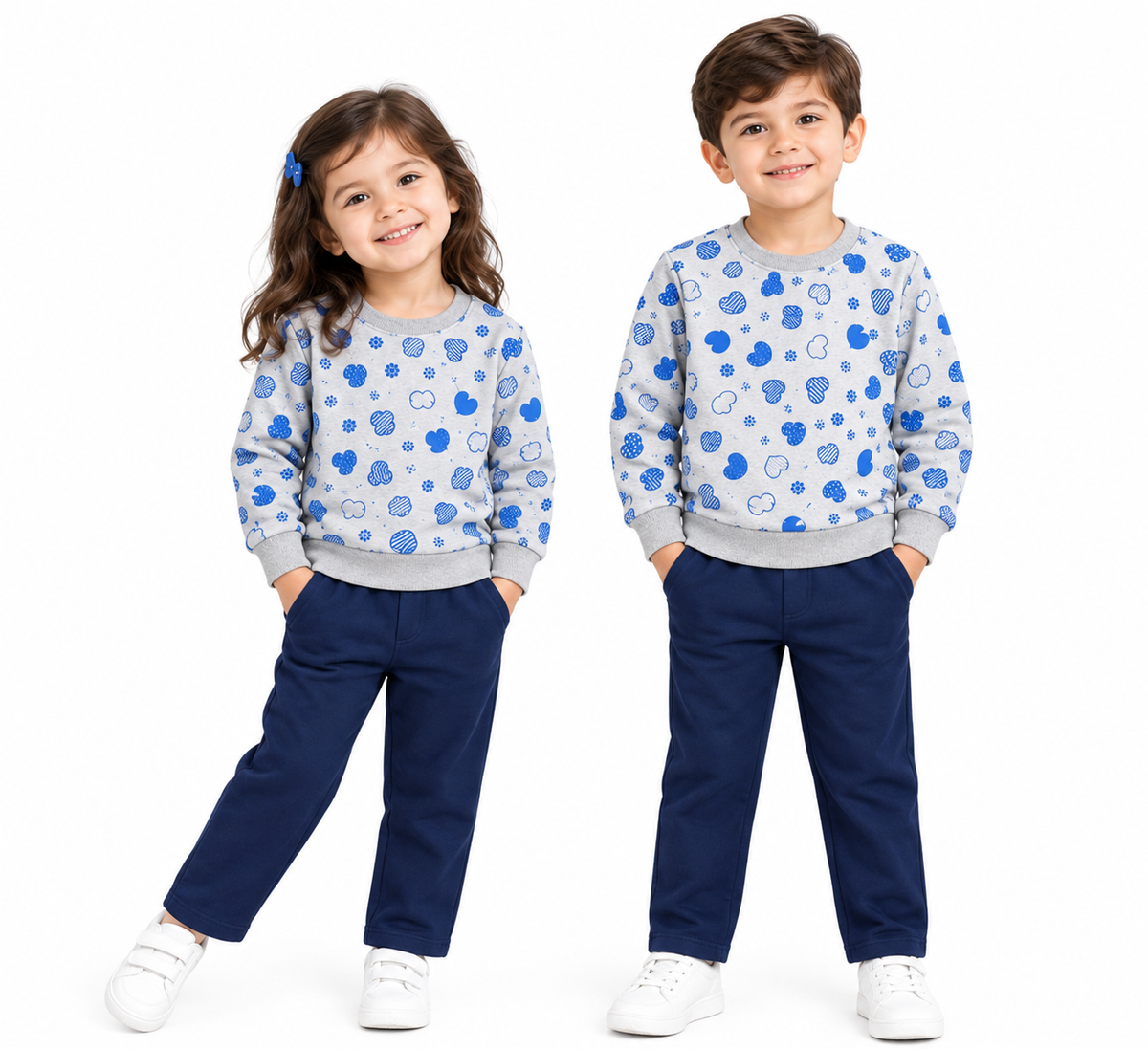 A young boy and girl modeling matching outfits. Both children wear light gray crewneck sweatshirts with a blue cloud pattern, paired with navy blue pants and white sneakers, set against a plain white background.