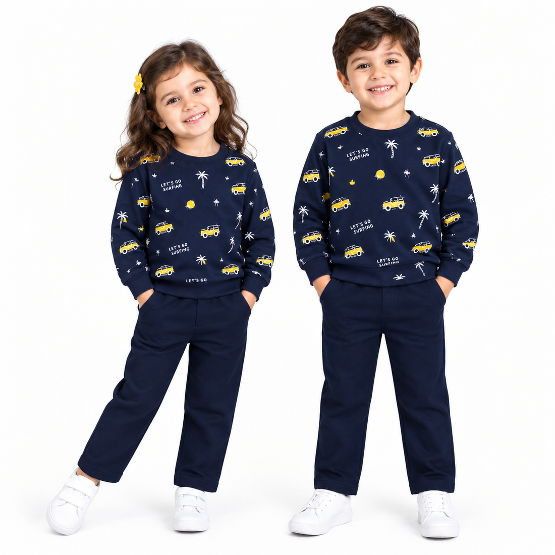 A children's two-piece pajama set featuring a navy blue sweatshirt and matching pants. The sweatshirt is decorated with a playful pattern of yellow vintage cars, white palm trees, and 'LET'S GO SUNNING' text.